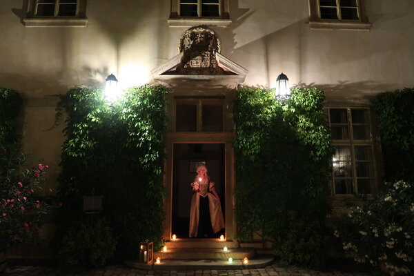 Žena v&nbsp;rokokových šatech se svící v&nbsp;ruce
